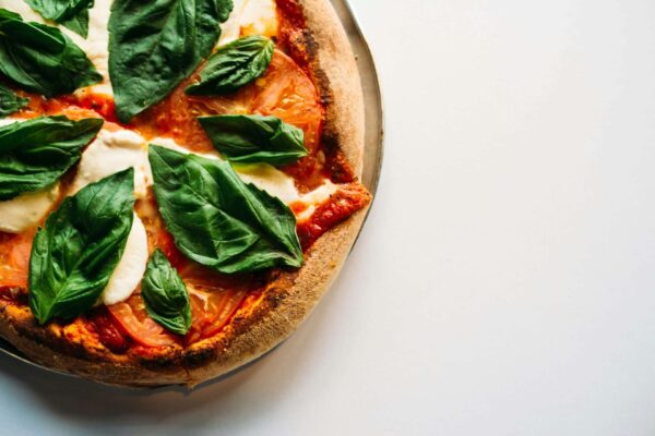Pizza mit Tomaten, Mozzarella und Basilikum